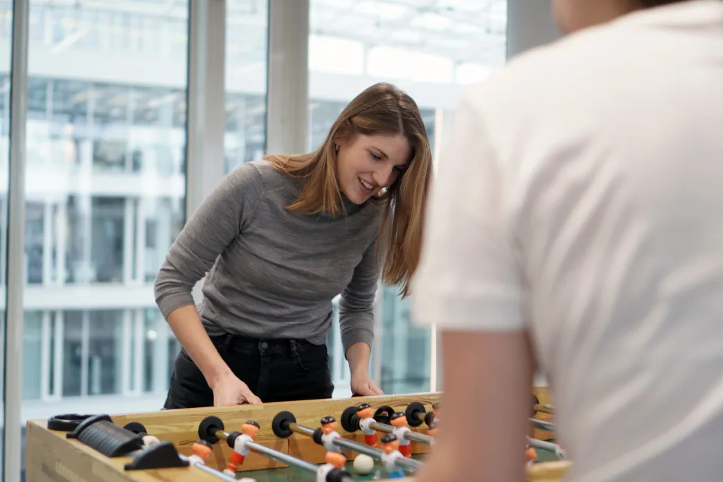 Two Elli designers happily playing a round of foosball at one of Elli's offices.